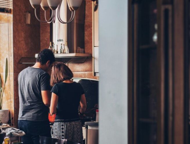 man and woman standing in front of gas range