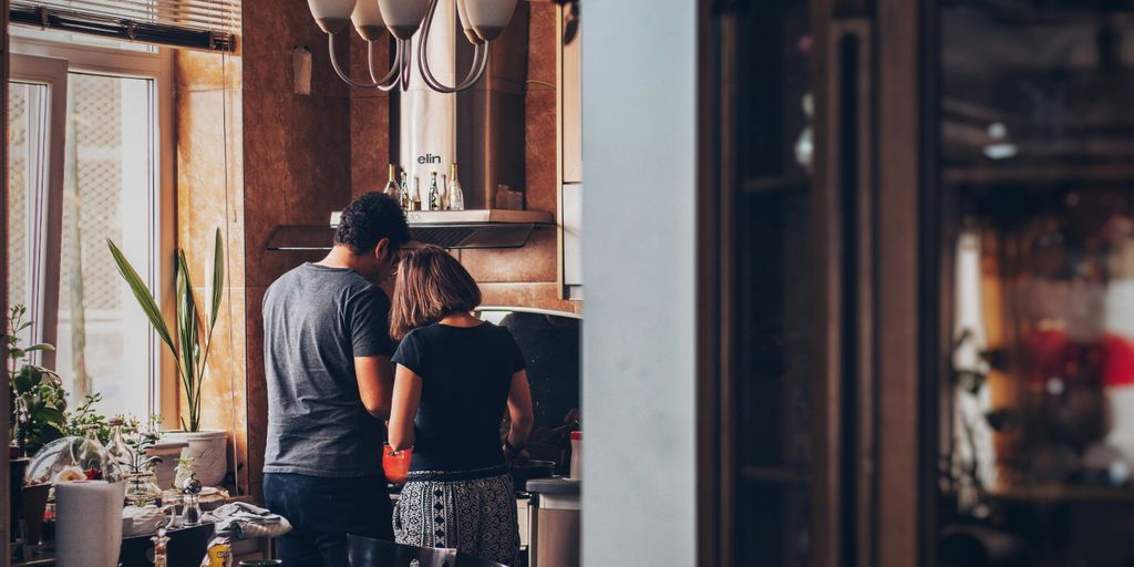 man and woman standing in front of gas range